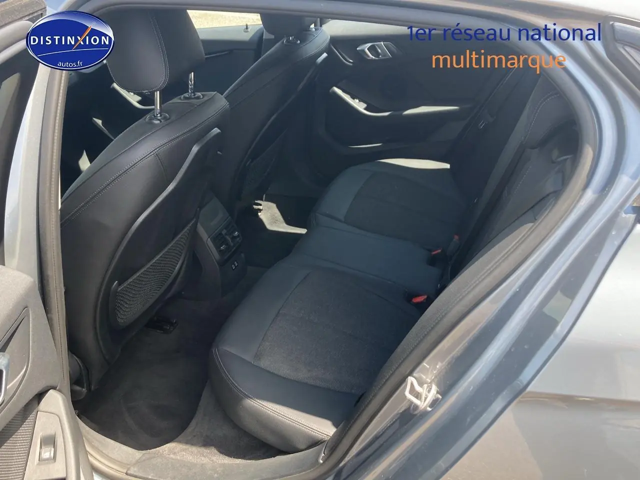 Vue intérieure côté gauche sur la banquette arrière en tissu et similicuir gris foncé d'une BMW Série 1 (f40) 118i 2023.