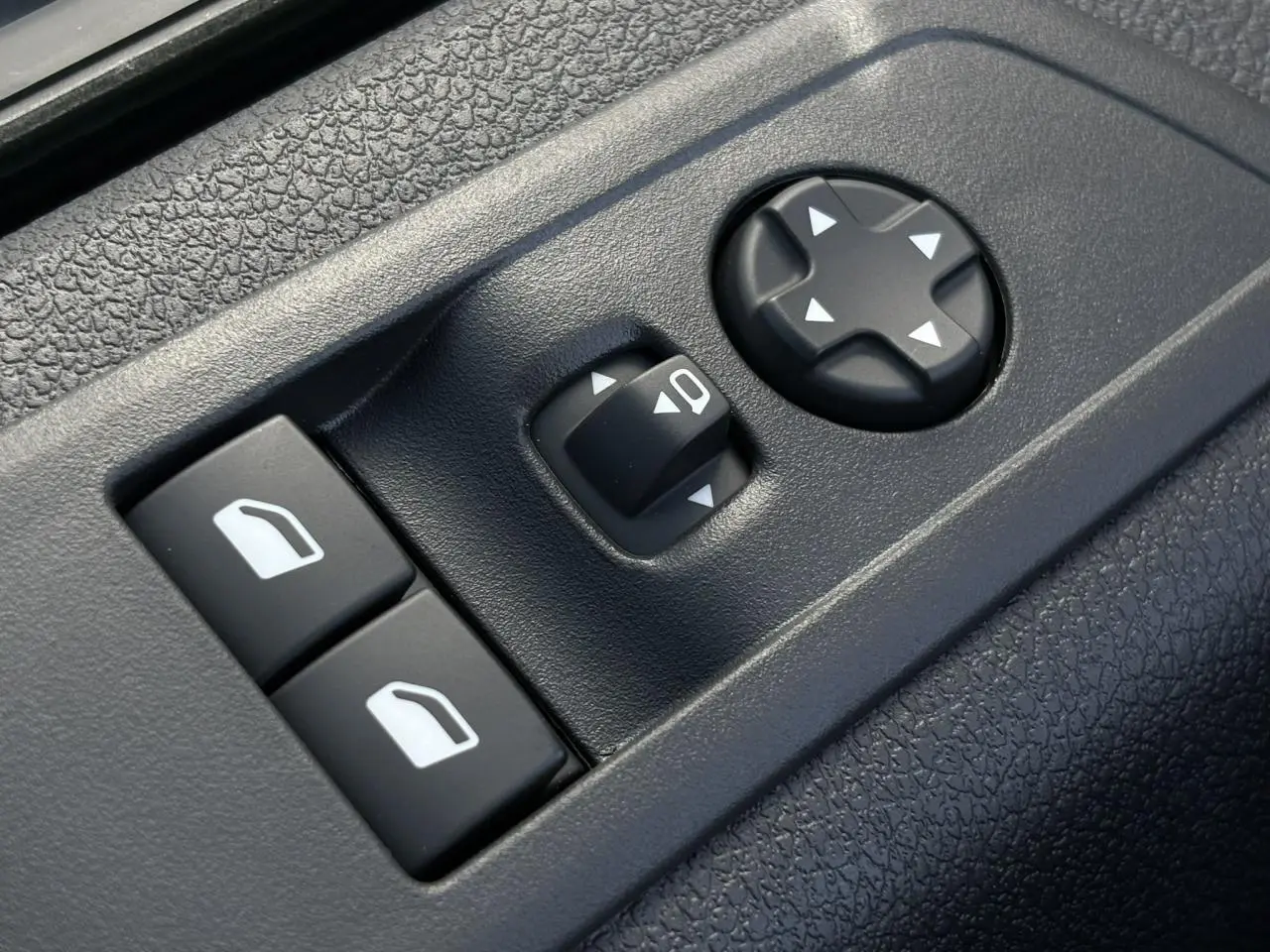 Gros plan sur les commandes de réglage des rétroviseurs et des vitres côté conducteur du Citroën Jumpy noir Perla.