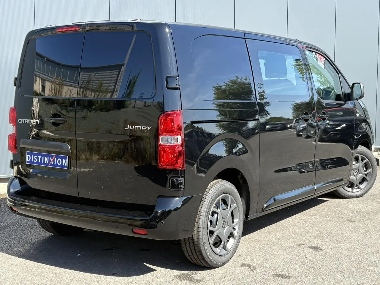 Vue 3/4 arrière droite d’un Citroën Jumpy noir Perla avec portes arrière battantes et vitres teintées.