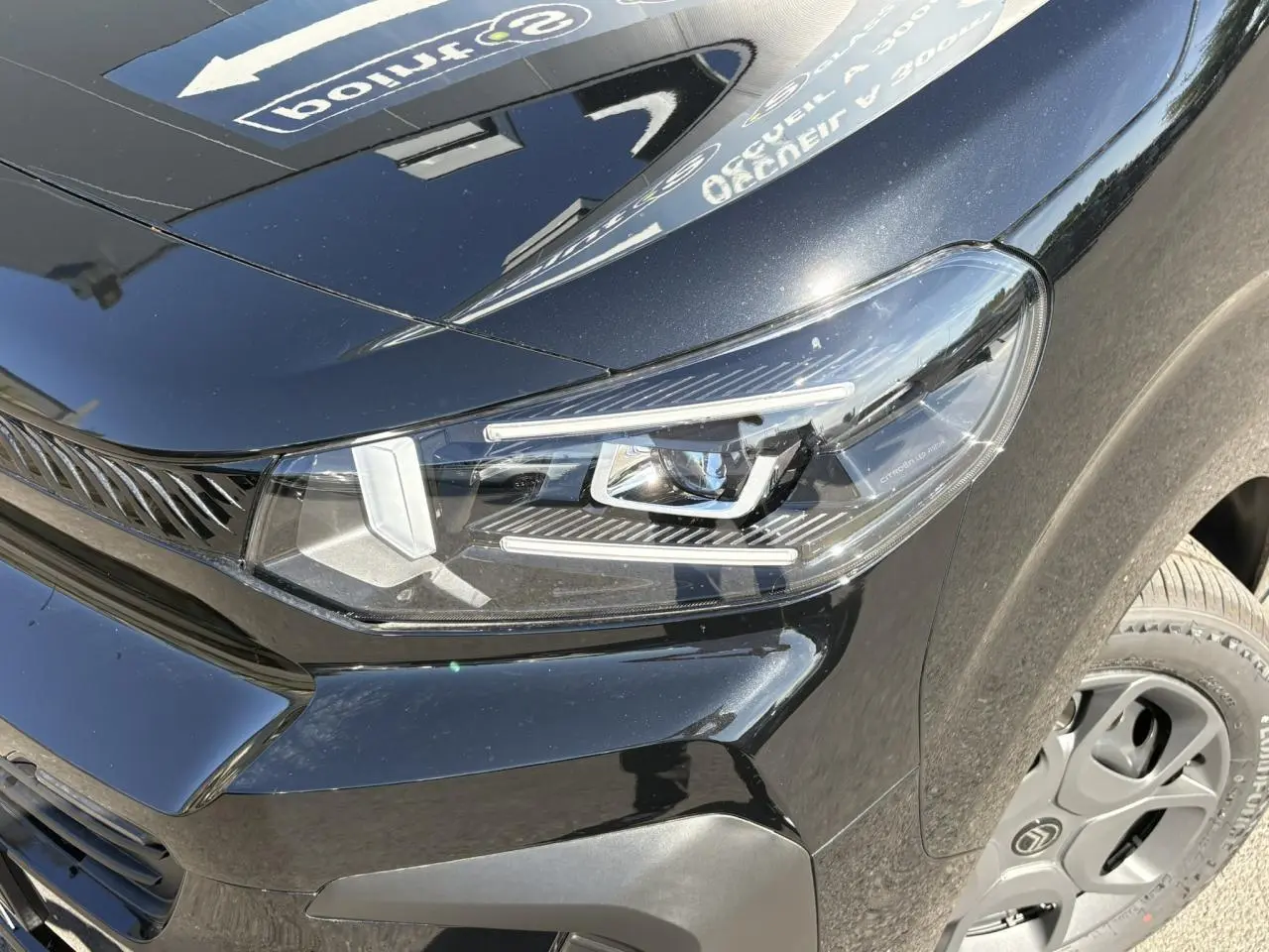 Gros plan sur le phare avant droit du Citroën Jumpy noir Perla avec jante tôle 17'' et détails du Pack Look.