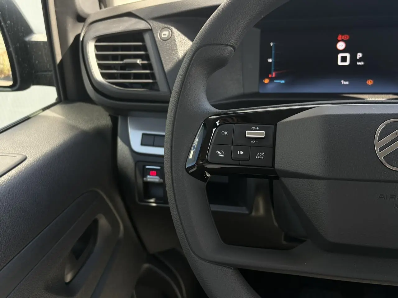 Vue rapprochée du volant côté gauche du Citroën Jumpy noir Perla avec commandes multifonctions et écran digital.