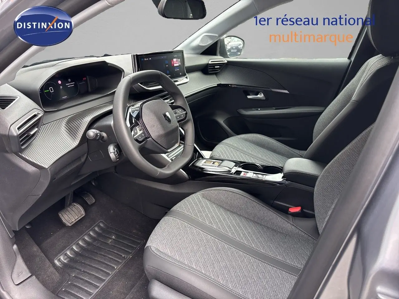Vue intérieure côté conducteur de la Peugeot 208 électrique 2026 avec sièges gris et tableau de bord moderne.