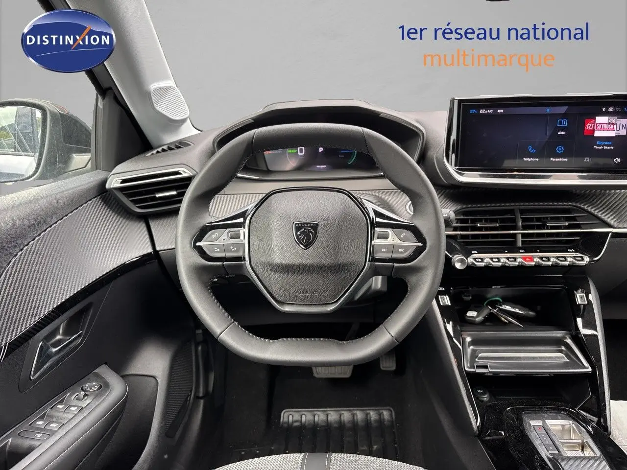 Vue intérieure centrée sur le volant et le tableau de bord de la Peugeot 208 électrique 2026 en finition Allure.