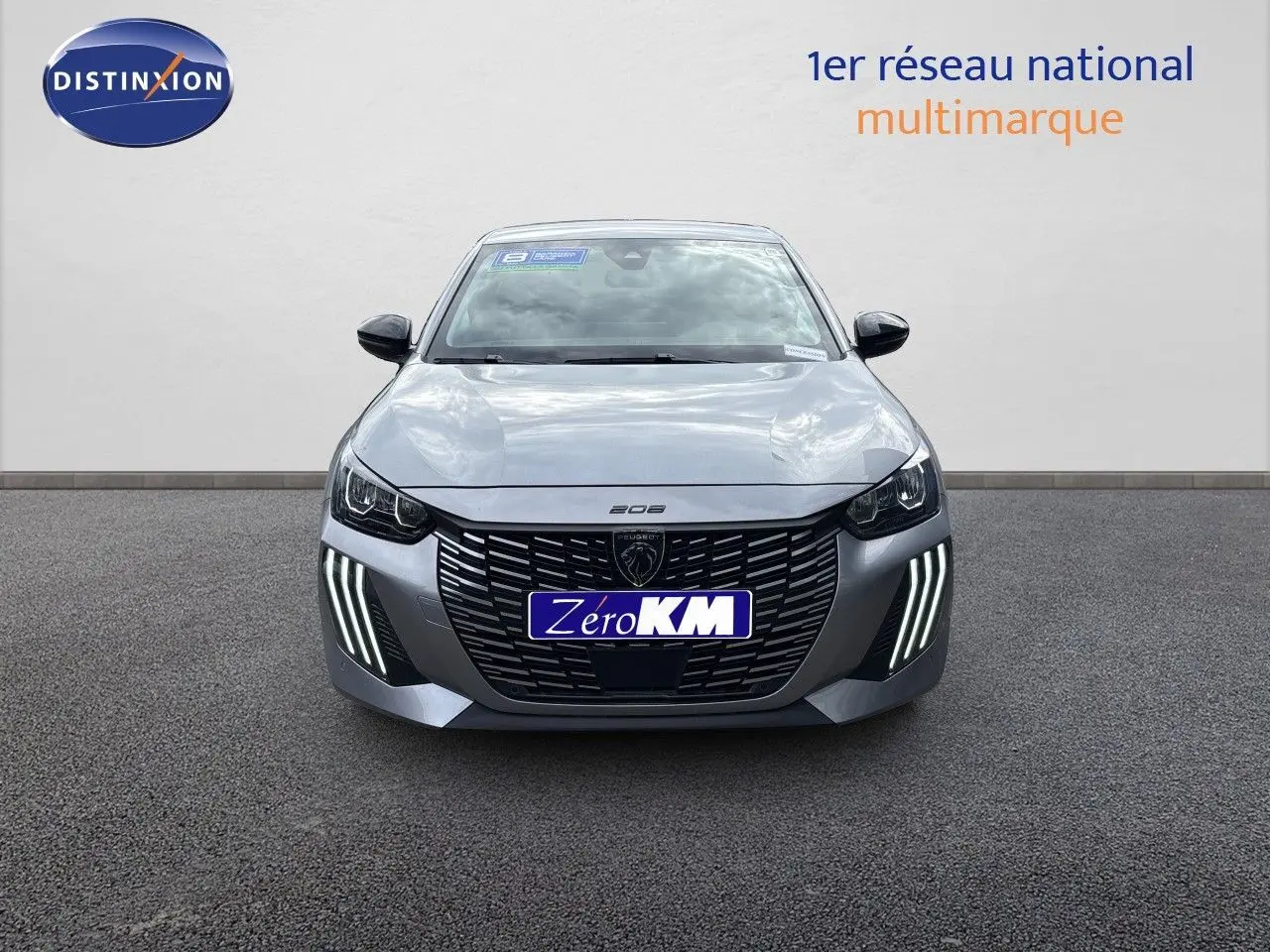 Vue avant d'une Peugeot 208 électrique gris Artense métal avec feux LED distinctifs allumés sur un fond neutre.