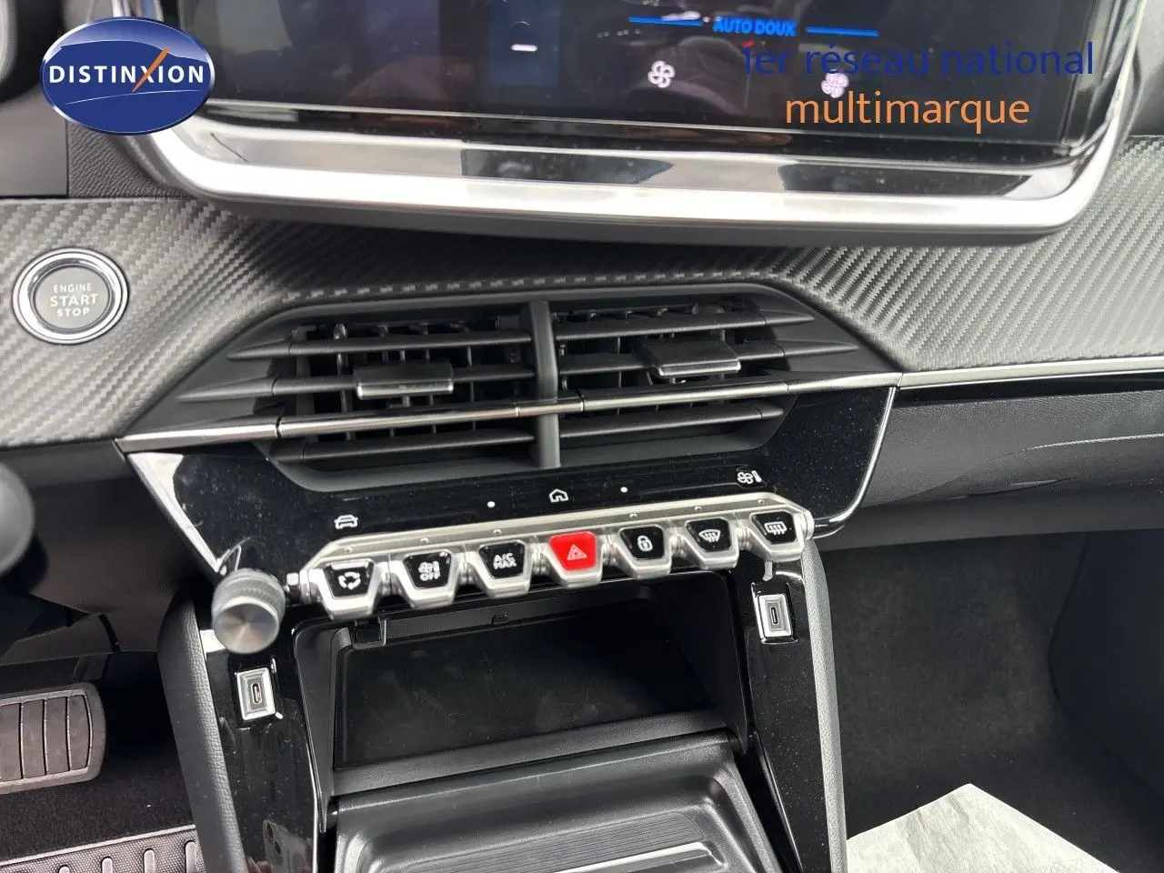 Gros plan sur la console centrale de la Peugeot 208 électrique gris Artense, avec boutons de commande et démarrage.