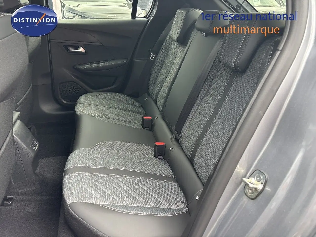 Vue côté droit des sièges arrière en tissu gris et cuir noir d'une Peugeot 208 électrique gris Artense métal, porte ouverte.
