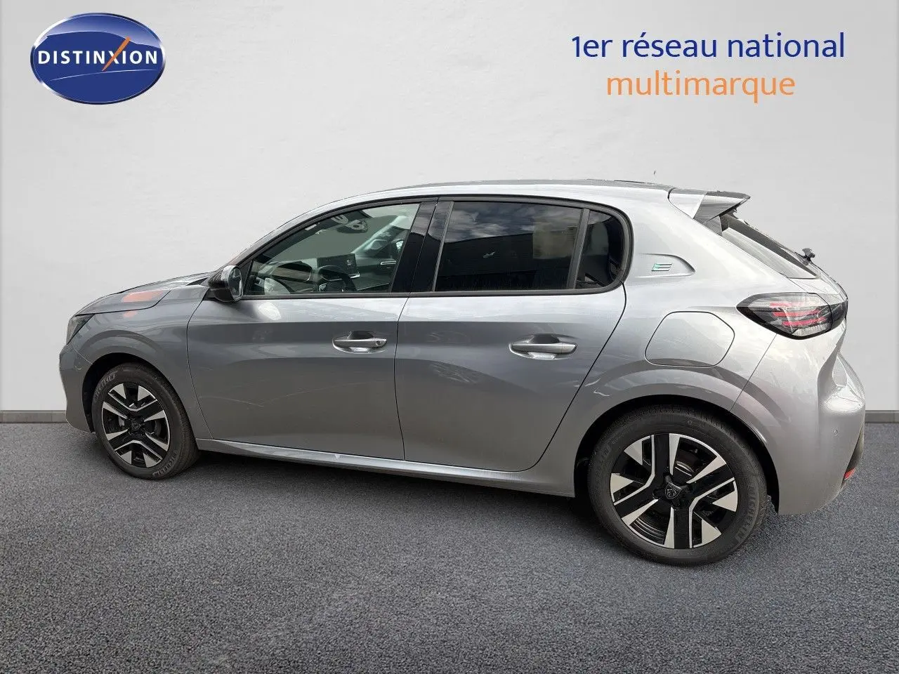 Peugeot 208 électrique gris Artense métal vue de profil côté gauche, avec jantes alliage distinctives et badge électrique arrière.