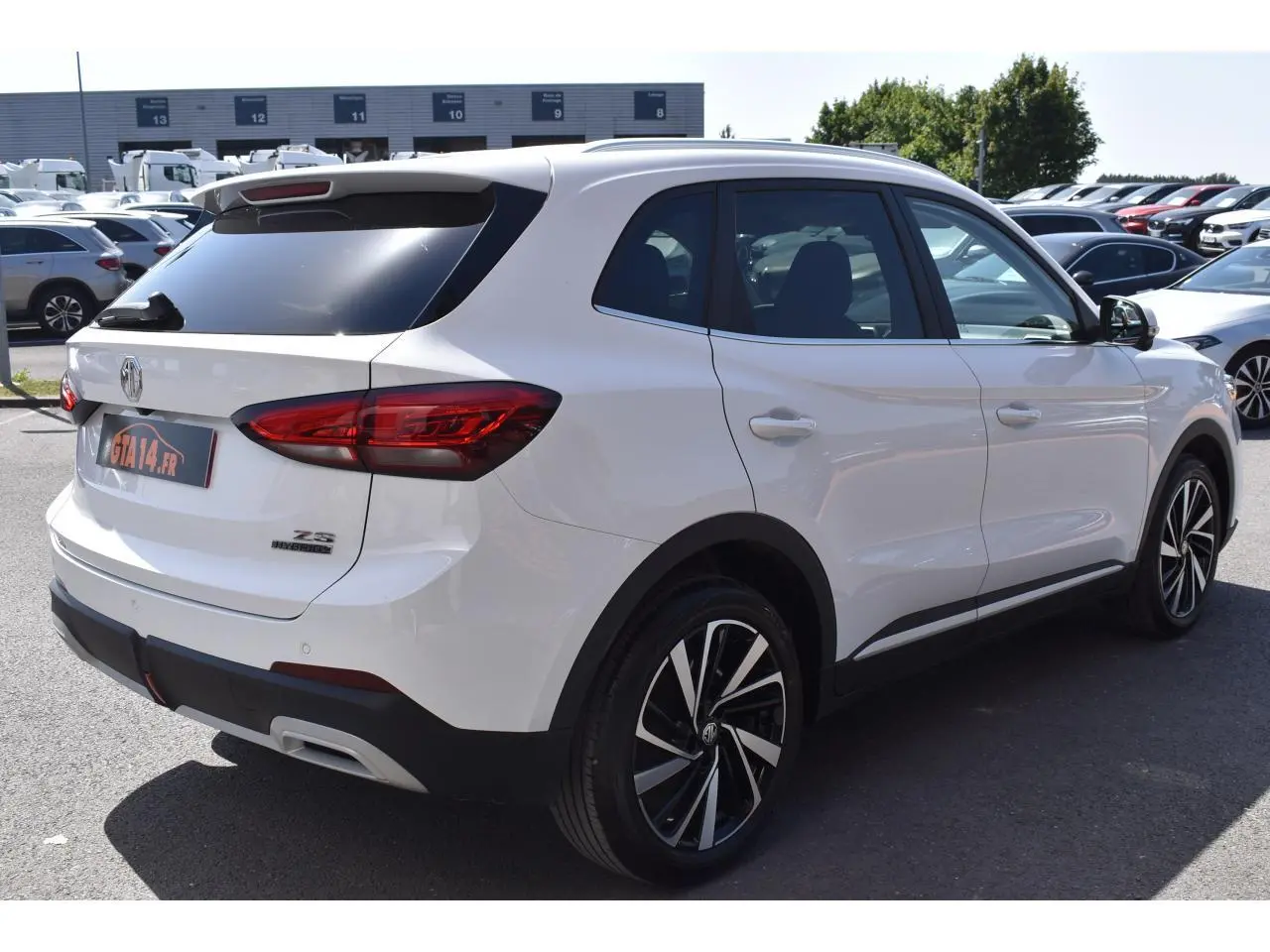 Vue 3/4 arrière droite du MG ZS blanc 2026, version MG III 1.5 HYBRID+ 197 LUXURY avec jantes alliage 18 pouces.