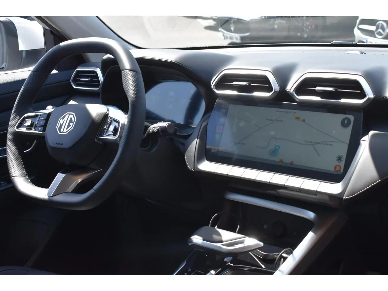 Vue intérieure du tableau de bord et volant du MG ZS blanc 2026 avec écran tactile et commandes au volant.