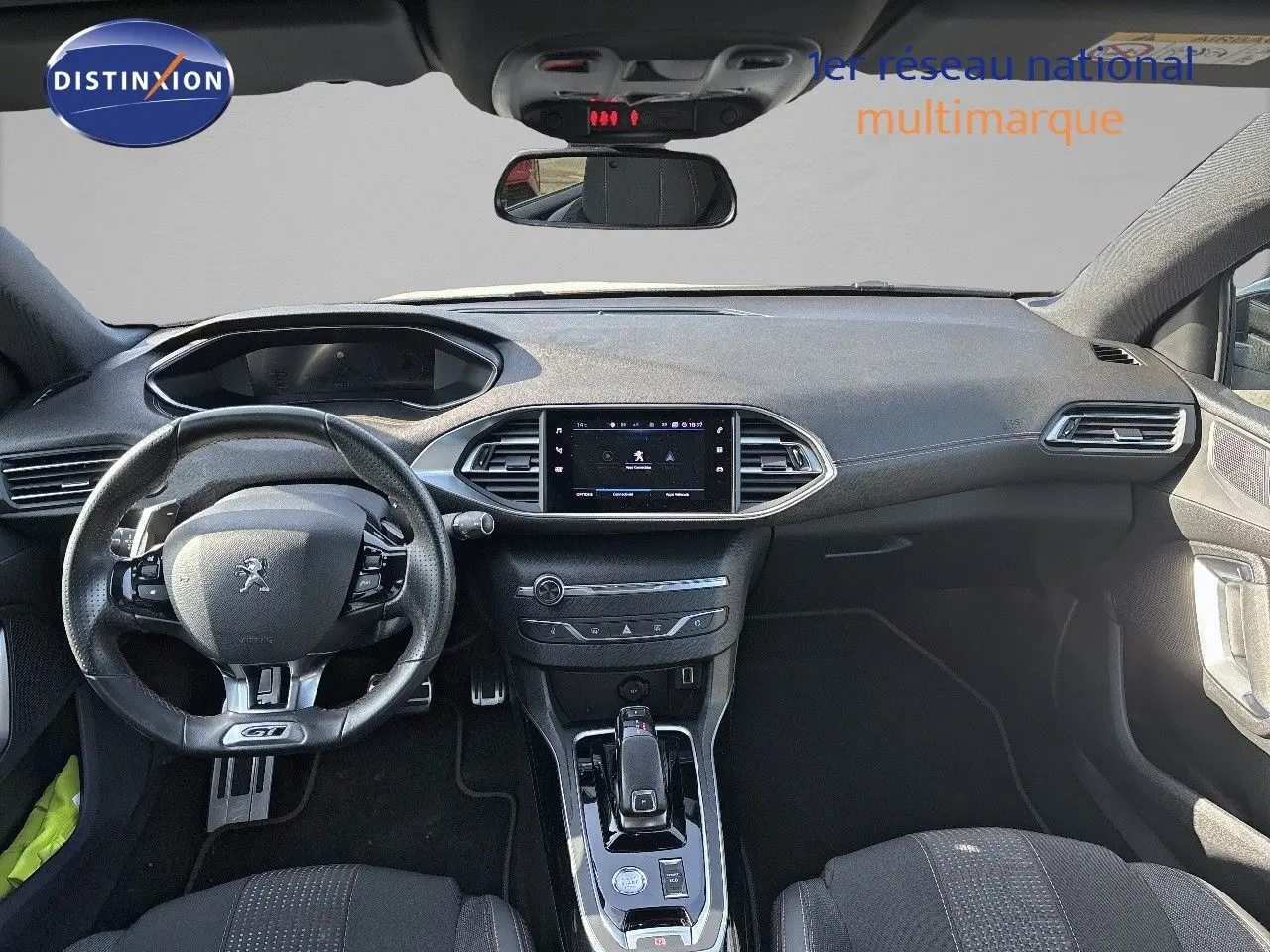Vue intérieure avant de la Peugeot 308 GT 2021 avec tableau de bord moderne et volant cuir perforé noir.