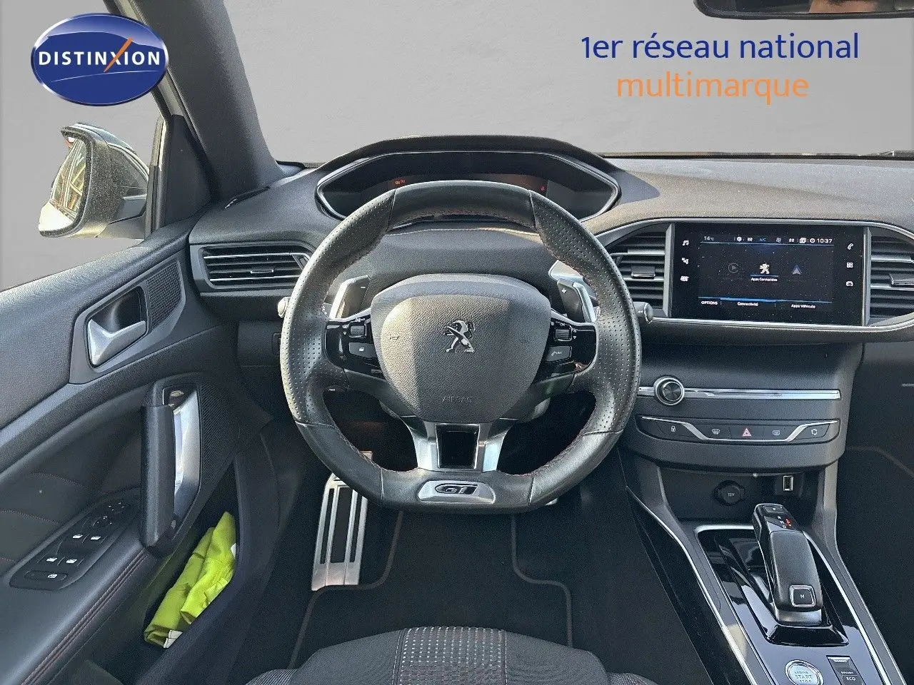 Vue intérieure centrée sur le volant cuir GT et la console centrale de la Peugeot 308 blanche nacrée de 2021.