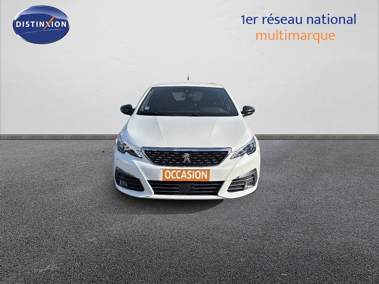 Peugeot 308 blanc nacré vue de face, avec calandre noire et plaque "OCCASION" orange visible.