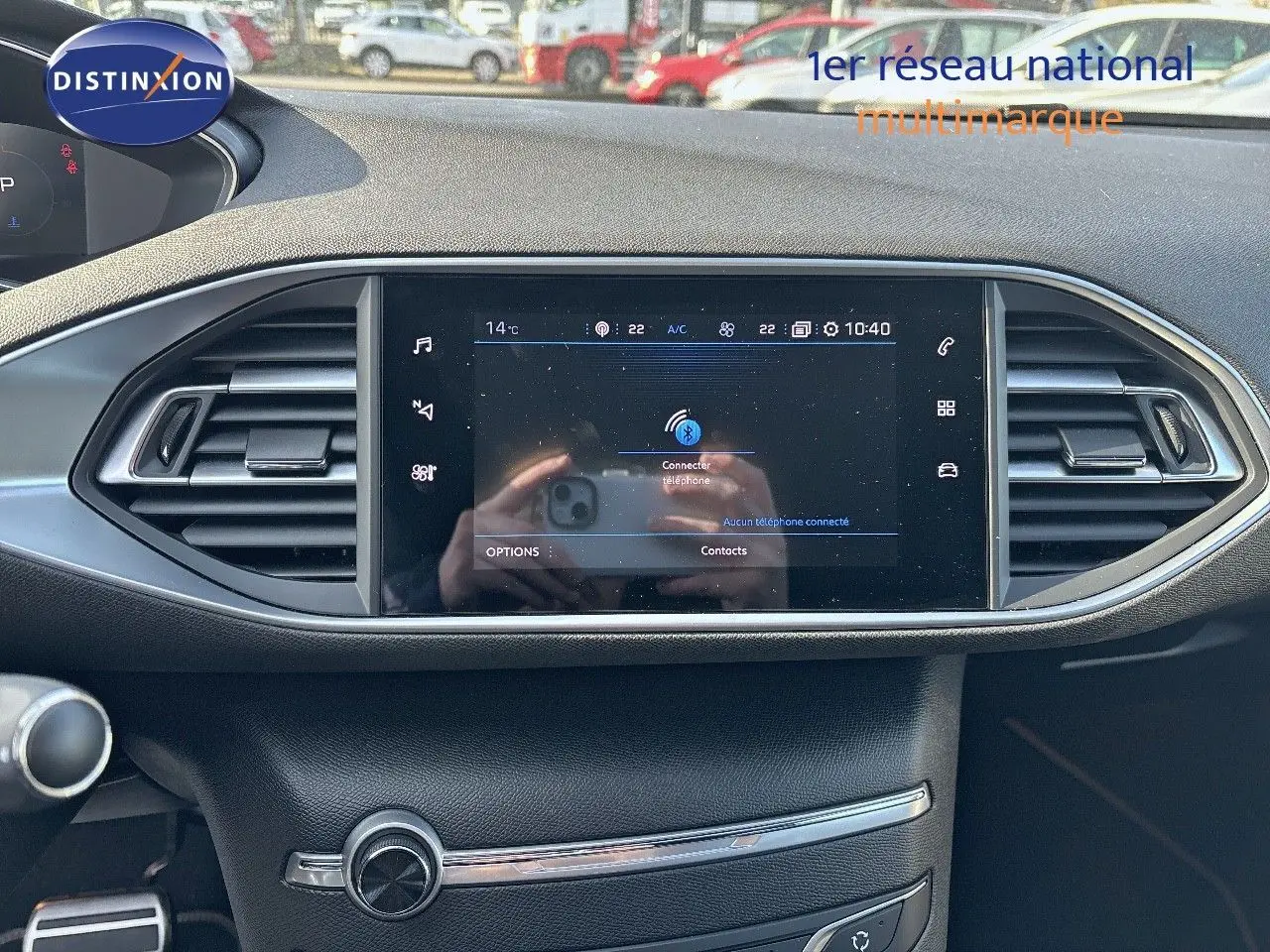 Écran tactile central du tableau de bord d'une Peugeot 308 GT 2021, avec commandes climatisation et aérateurs.