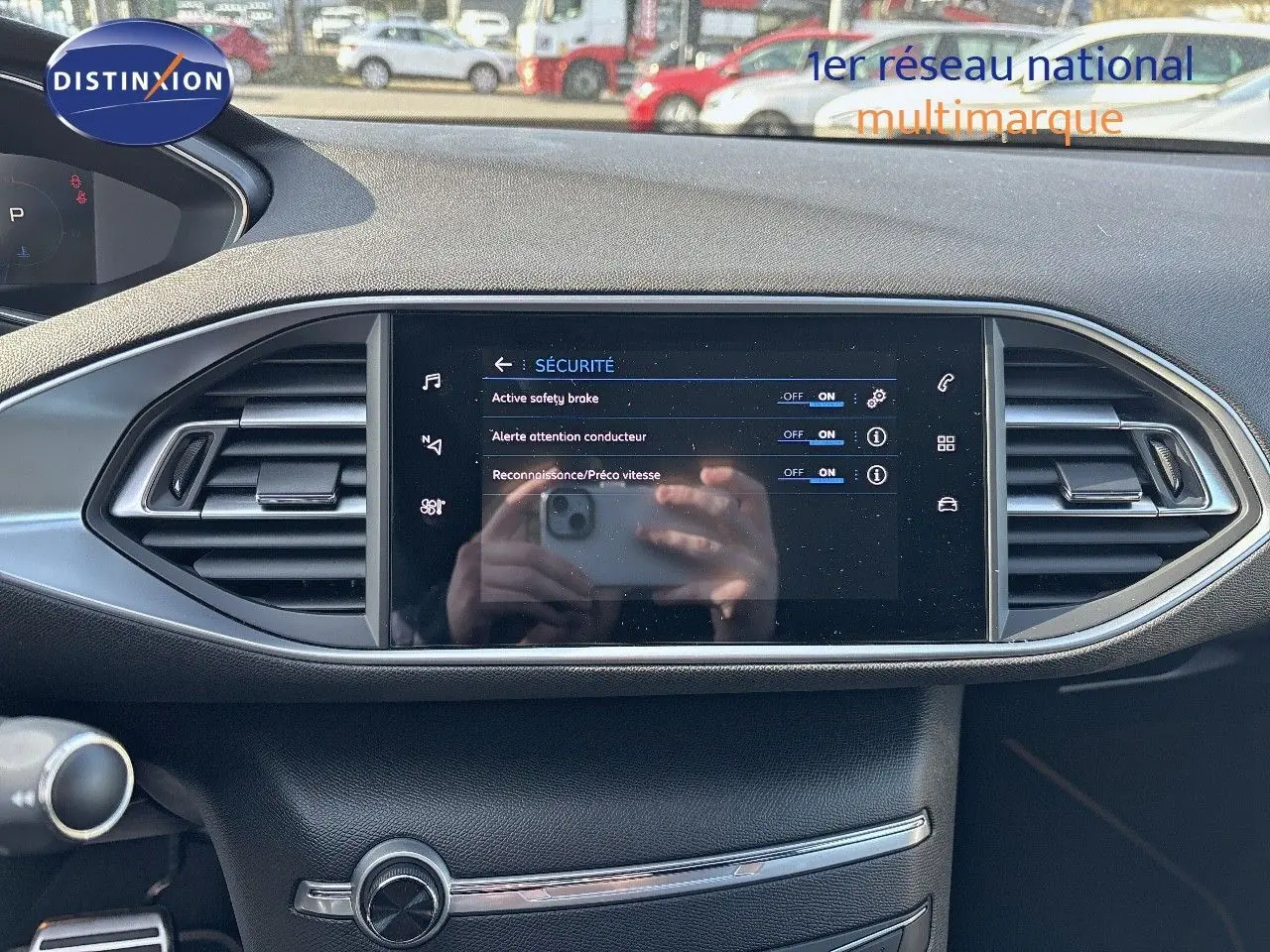 Vue rapprochée de l'écran tactile central et des aérateurs du tableau de bord d'une Peugeot 308 blanc nacré 2021.