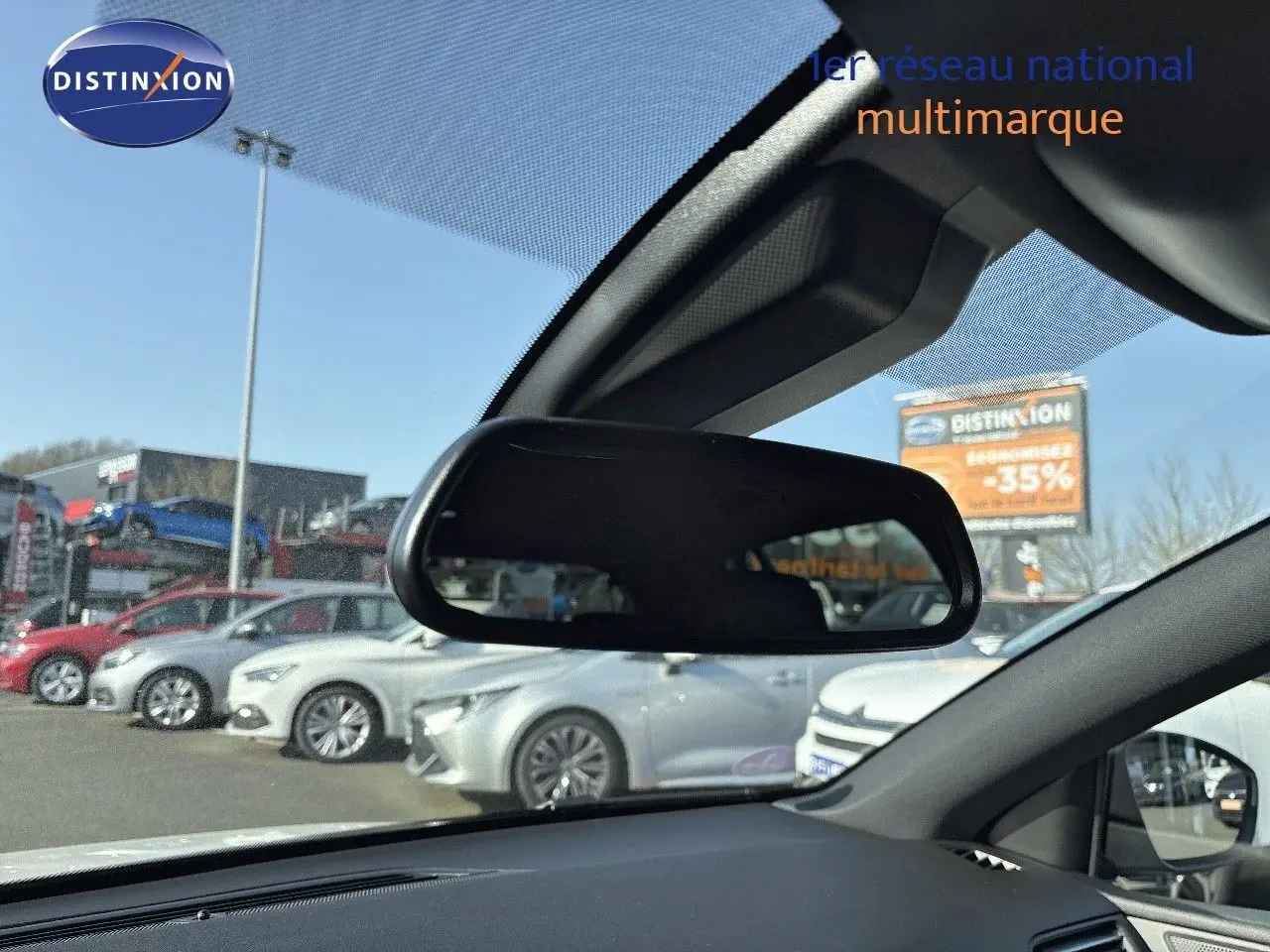 Vue depuis l'intérieur montrant le rétroviseur central et en arrière-plan une Peugeot 308 blanc nacré en extérieur.