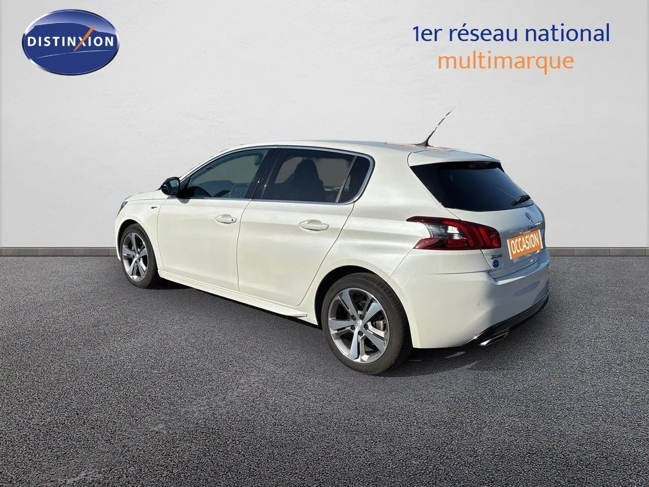 Peugeot 308 blanc nacré vue 3/4 arrière côté gauche, avec jantes alliage et vitres teintées.