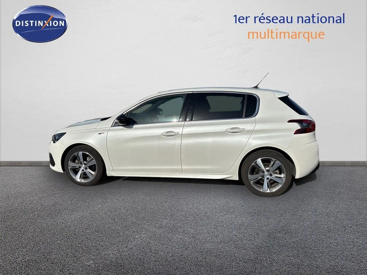 Profil côté gauche d'une Peugeot 308 blanc nacré 5 portes, version GT essence 2021, sur fond neutre.