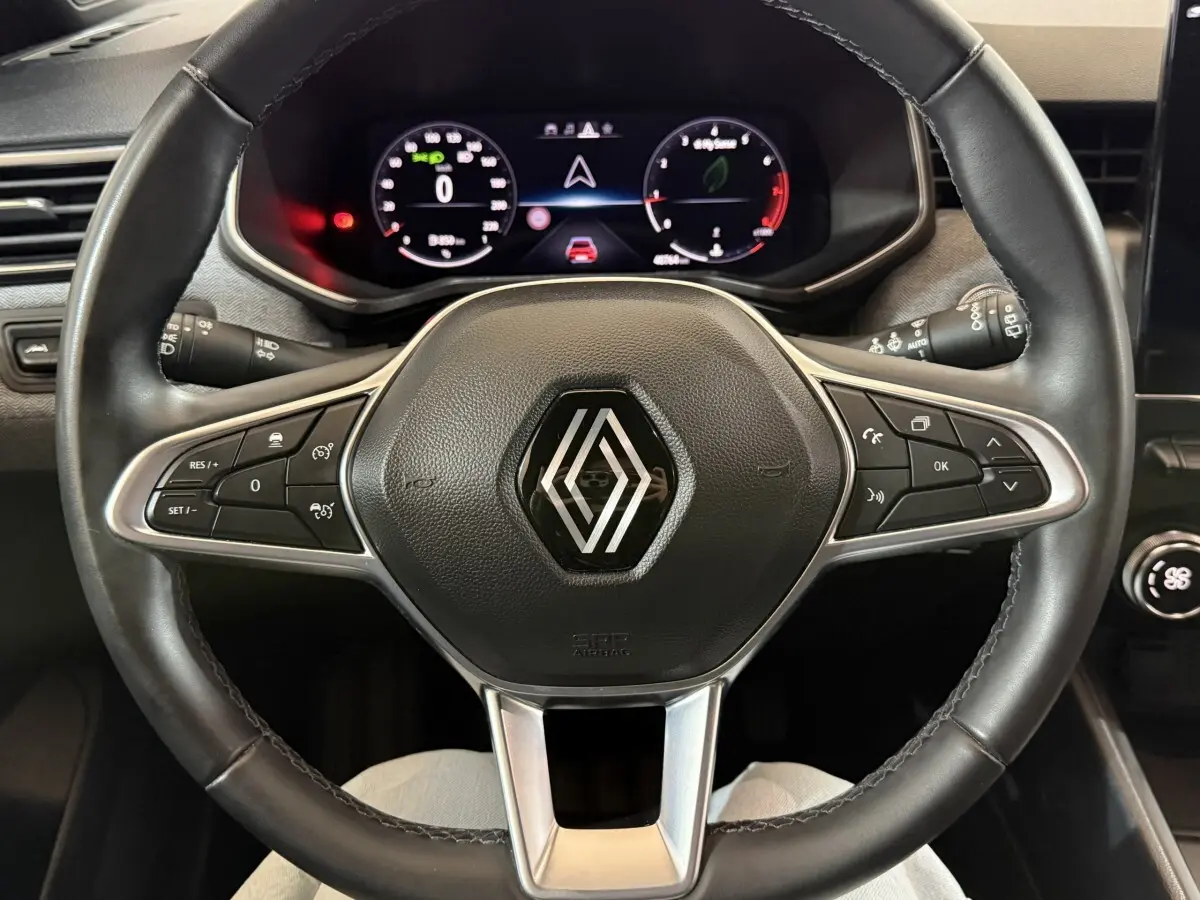 Vue rapprochée du volant en cuir noir de la Renault Clio Techno TCe 90 2024 avec tableau de bord numérique.