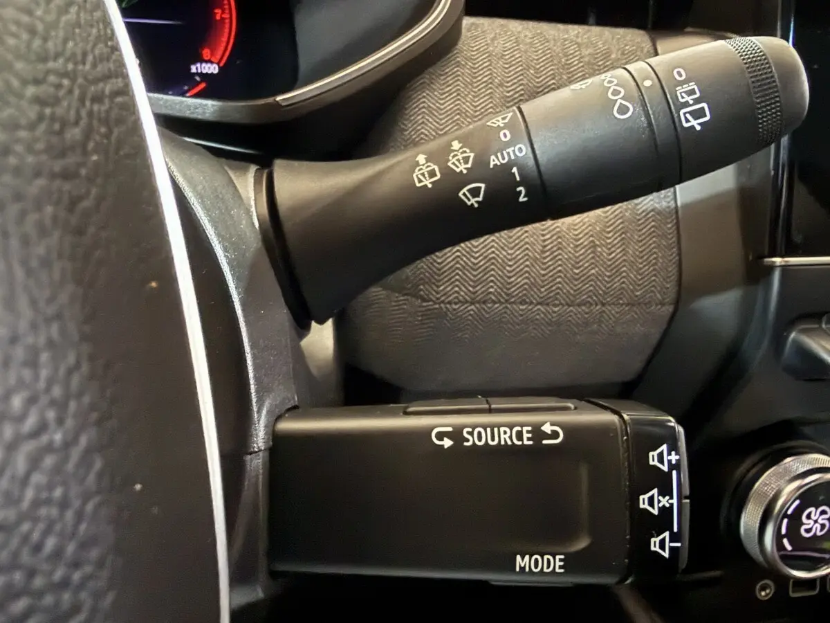 Gros plan sur les commandes au volant à gauche de la Renault Clio Techno TCe 90 2024, avec boutons source et mode.