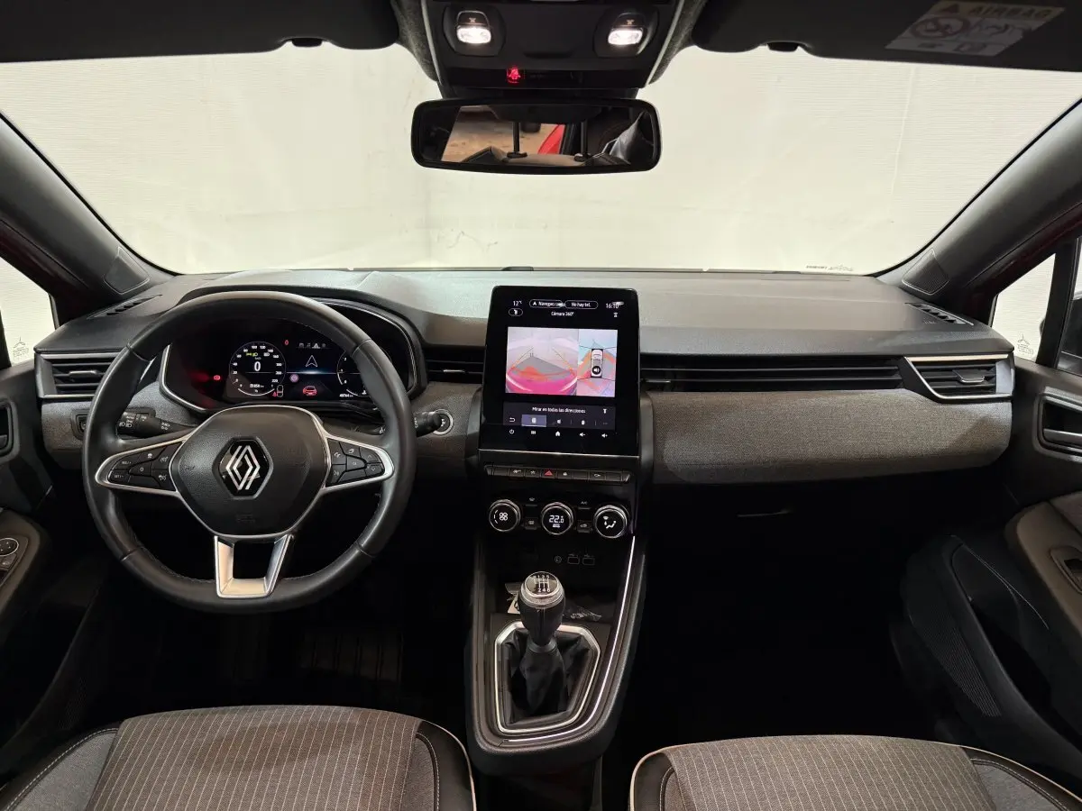 Vue intérieure avant de la Renault Clio Techno TCe 90 2024, tableau de bord avec écran tactile vertical et volant multifonctions.