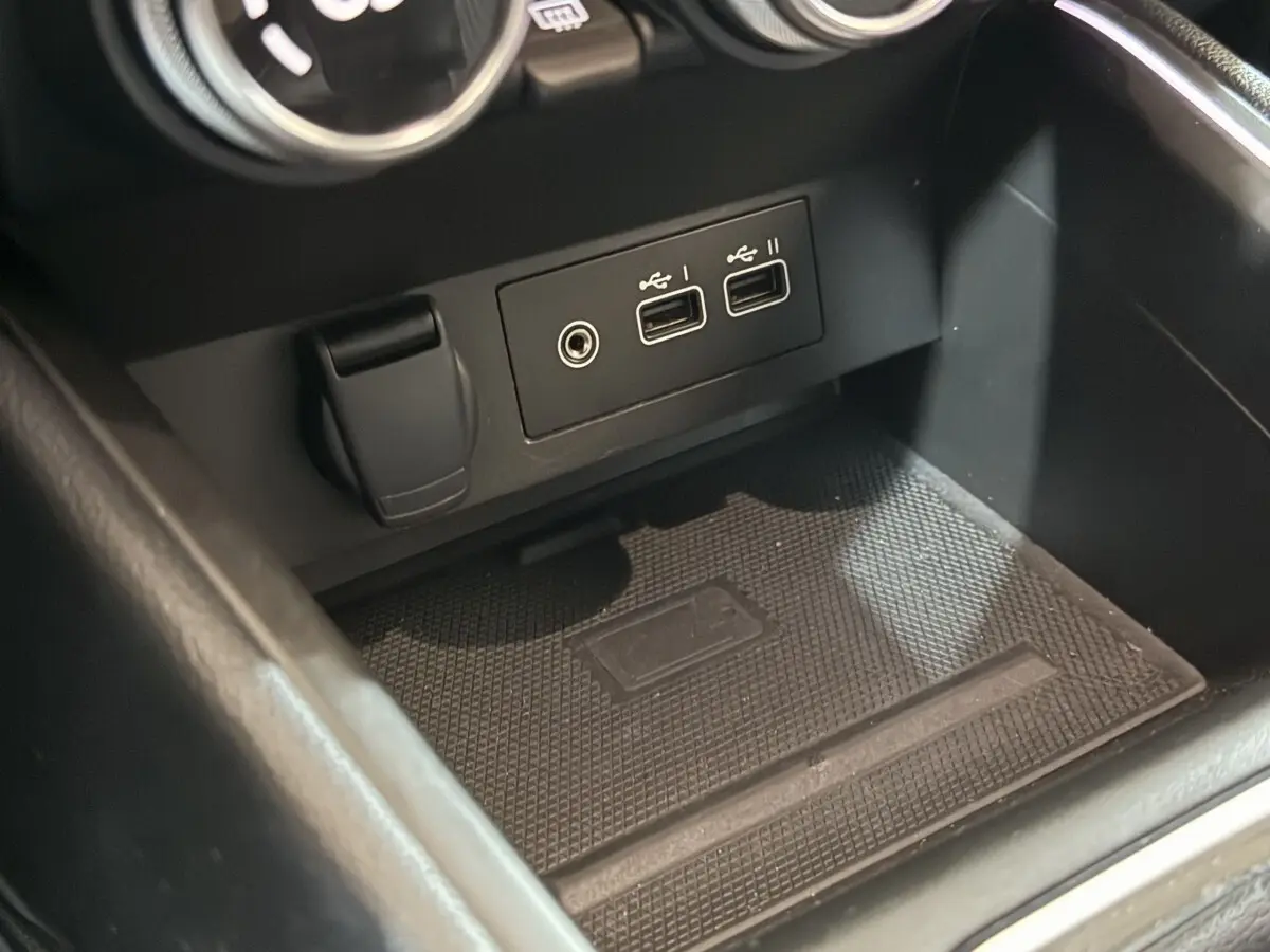 Gros plan sur la console centrale noire de la Renault Clio Techno TCe 90 avec ports USB et prise 12V visibles.