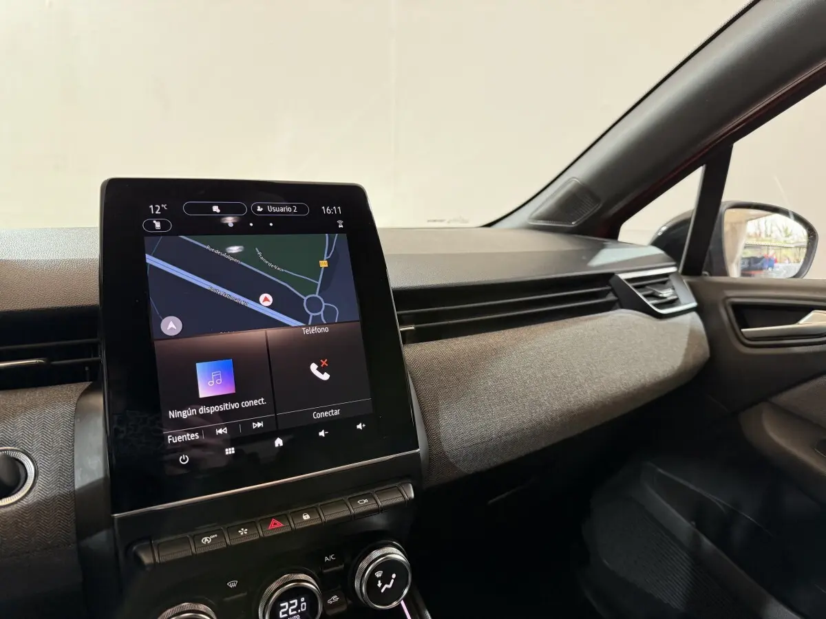 Vue intérieure côté passager de la Renault Clio Techno TCe 90 2024 rouge, avec écran tactile central et tableau de bord texturé.