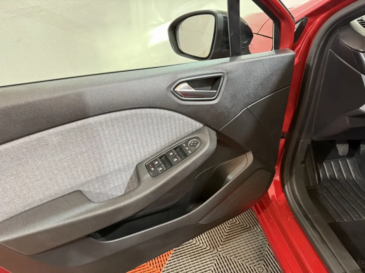 Vue intérieure côté gauche de la porte avant rouge de la Renault Clio 2024 avec commandes des vitres et rétroviseur.
