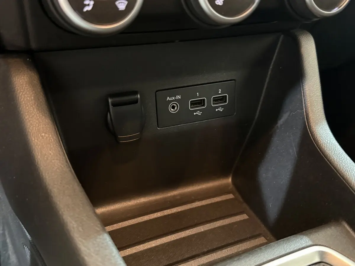 Gros plan sur la console centrale noire de la Renault Clio Business avec ports USB et prise Aux-IN visibles.
