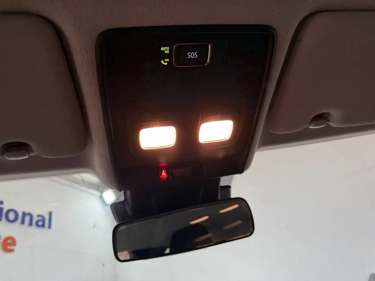 Plafonnier avec éclairage intérieur allumé et bouton SOS visible dans l’habitacle d’une Renault Clio blanche.