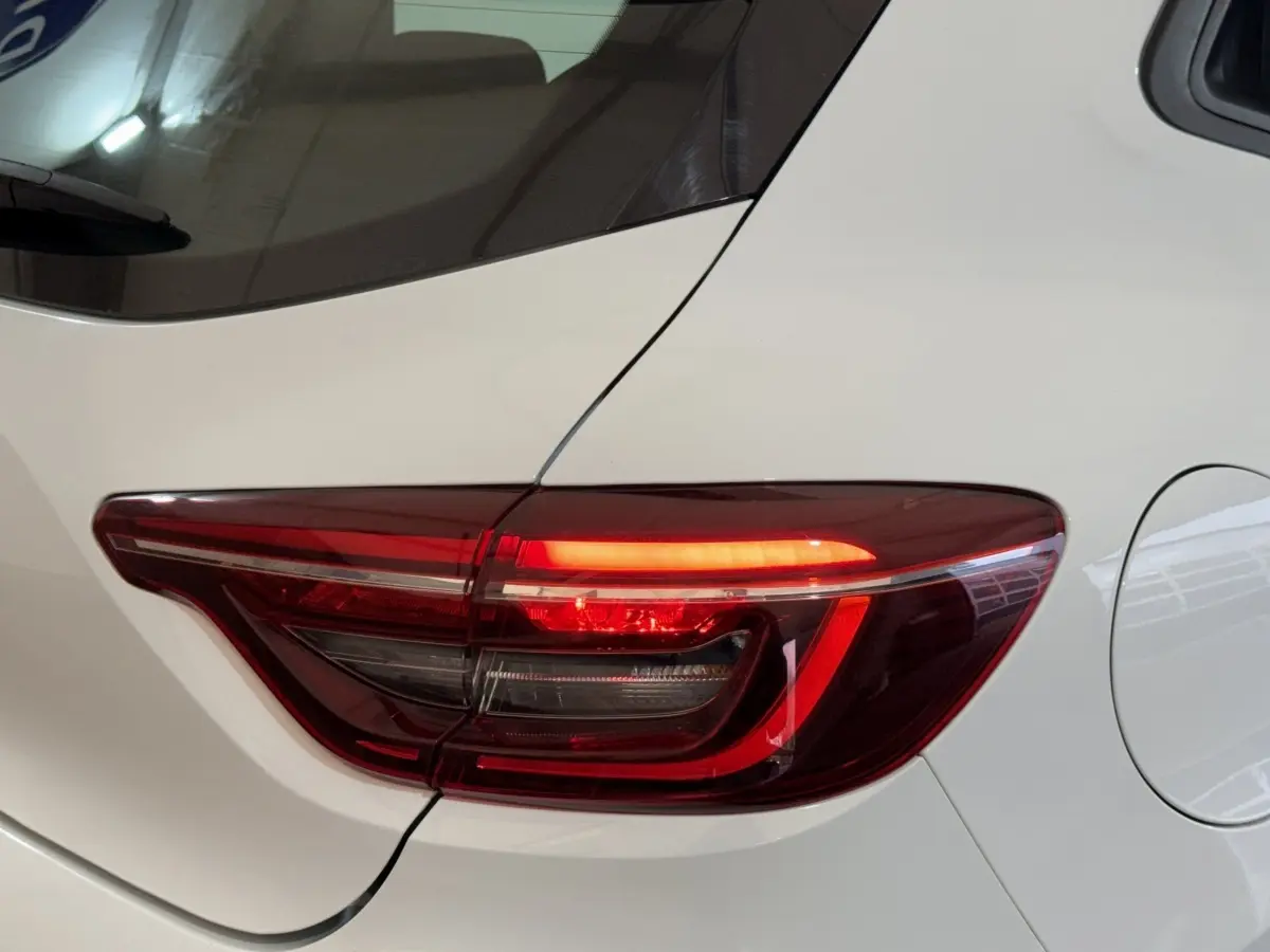 Gros plan sur le feu arrière droit rouge de la Renault Clio Business blanche, avec la trappe à carburant visible.