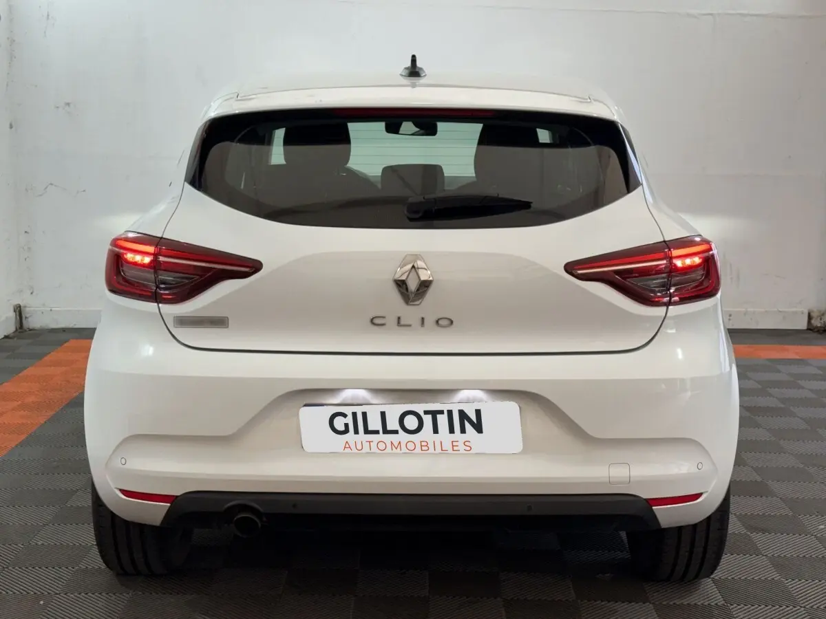 Vue arrière d'une Renault Clio Business blanche 2021 avec feux LED allumés et plaque d'immatriculation GILLOTIN.