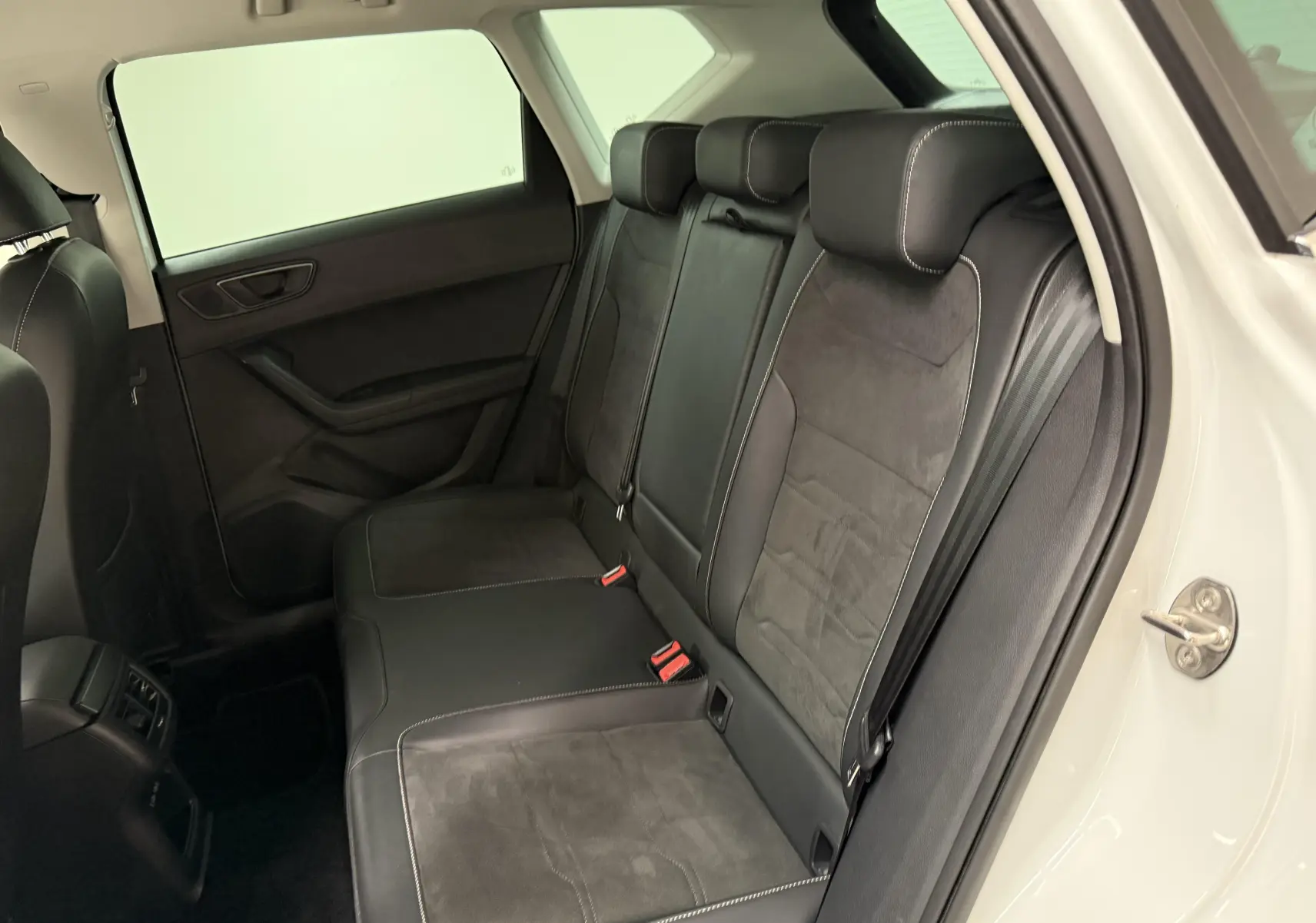 Vue intérieure côté droit des sièges arrière en cuir noir avec surpiqûres blanches du SEAT Ateca blanc Nevada 2023.