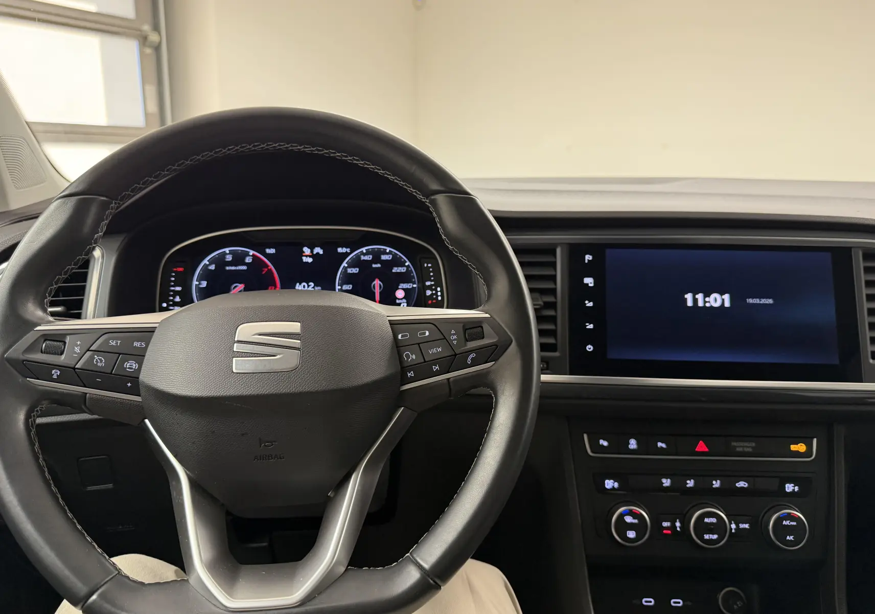 Vue intérieure centrée sur le volant et le tableau de bord numérique du SEAT Ateca 2023, ambiance sobre et moderne.