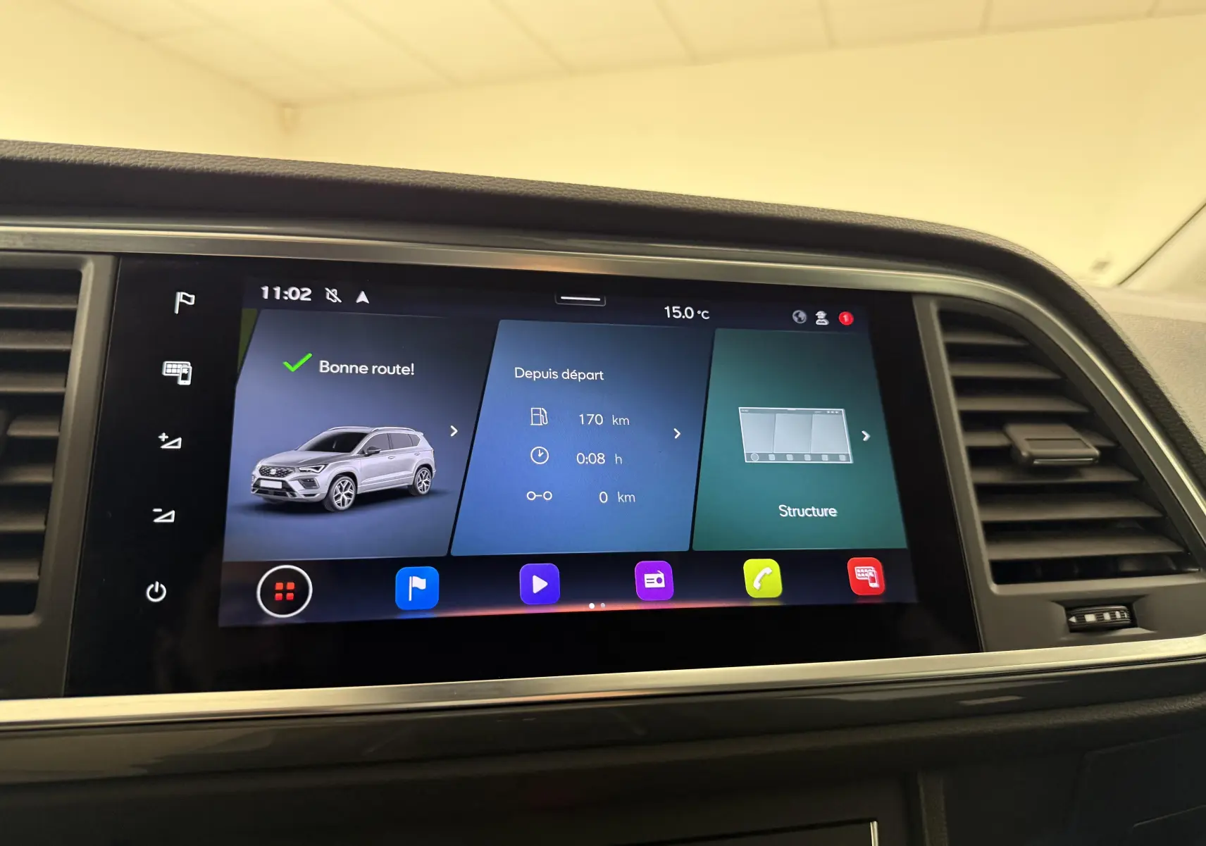 Écran tactile central affichant l'interface multimédia du SEAT Ateca blanc Nevada, vue intérieure frontale.