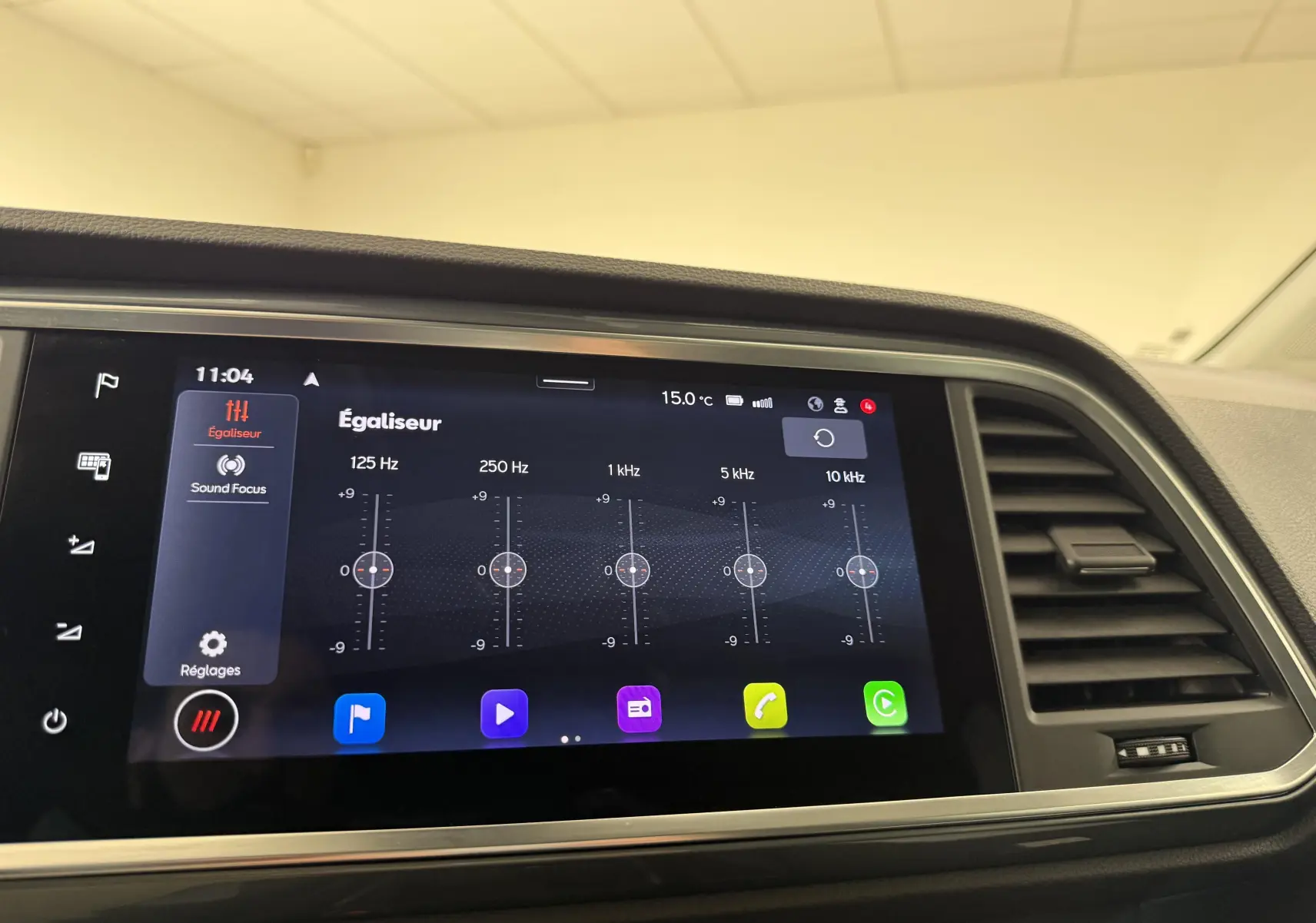 Écran tactile intérieur du SEAT Ateca 2023 montrant l'égaliseur audio, avec tableau de bord noir et aérateurs latéraux.