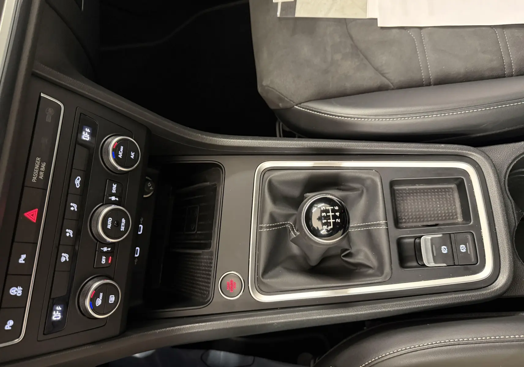 Vue plongeante sur la console centrale du SEAT Ateca blanc Nevada 2023, mettant en valeur le levier de vitesses manuel et les commandes climatisation.