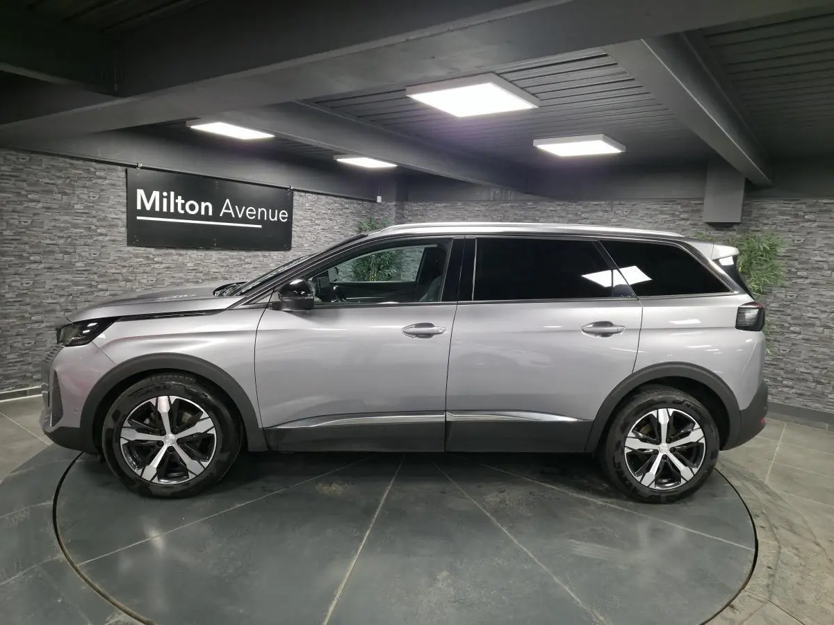 Peugeot 5008 gris métallisé vue de profil côté gauche, avec jantes alliage bi-ton et vitres surteintées.