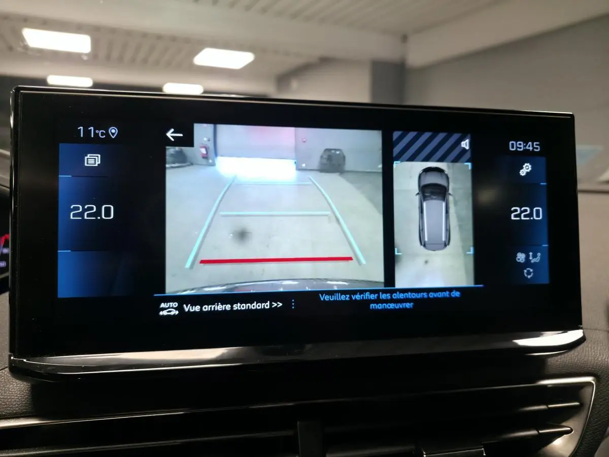 Écran tactile intérieur du Peugeot 5008 gris montrant la caméra 360° avec vue arrière et vue du dessus du véhicule.