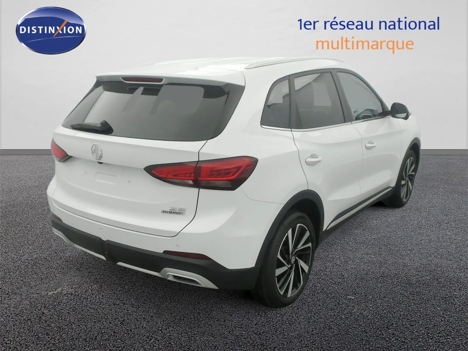 Vue 3/4 arrière droit du MG ZS 1.5 L Hybrid+ Dover White avec jantes alliage 18 pouces et vitres surteintées.