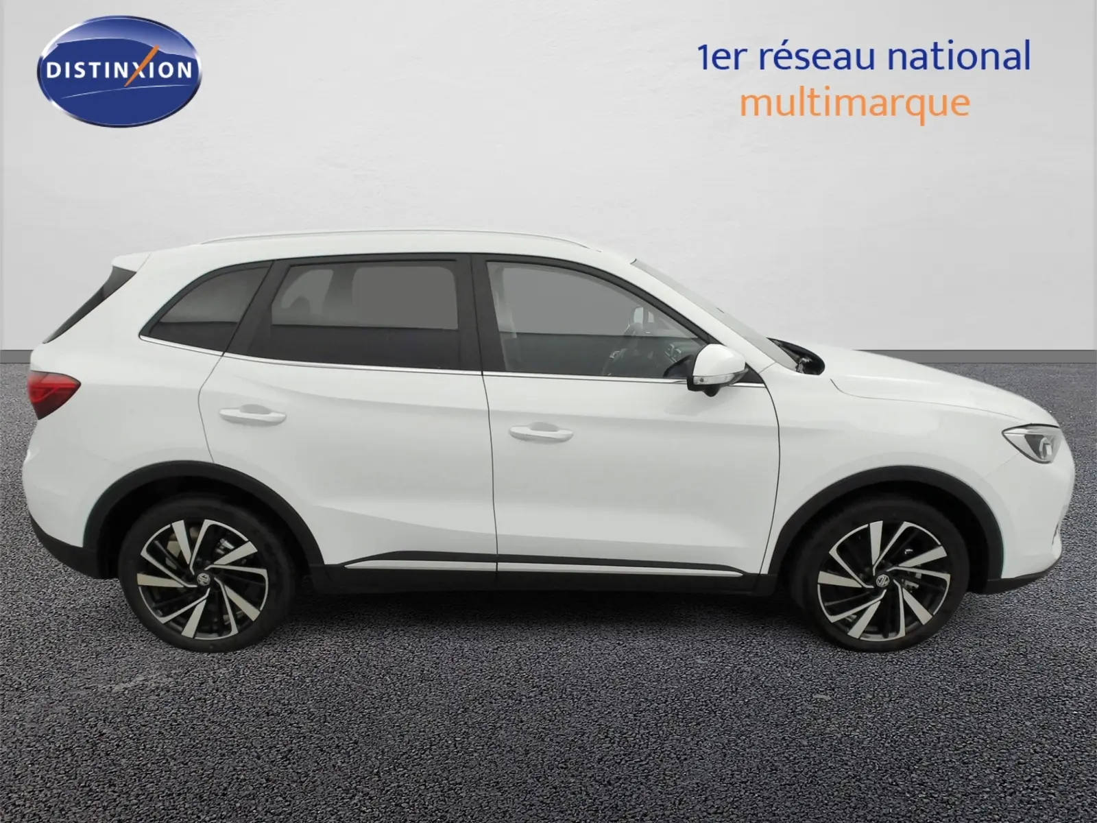 Vue de profil côté droit du SUV MG ZS 1.5 L Hybrid+ 197 ch Luxury en blanc Dover avec jantes alliage 18 pouces.