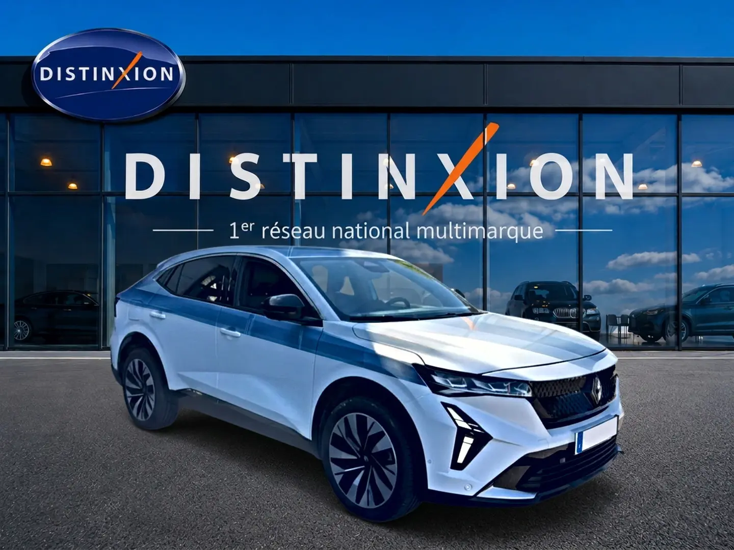 Renault Rafale blanc en 3/4 avant droit, avec feux LED et jantes alu distinctives, devant vitrine Distinxion.