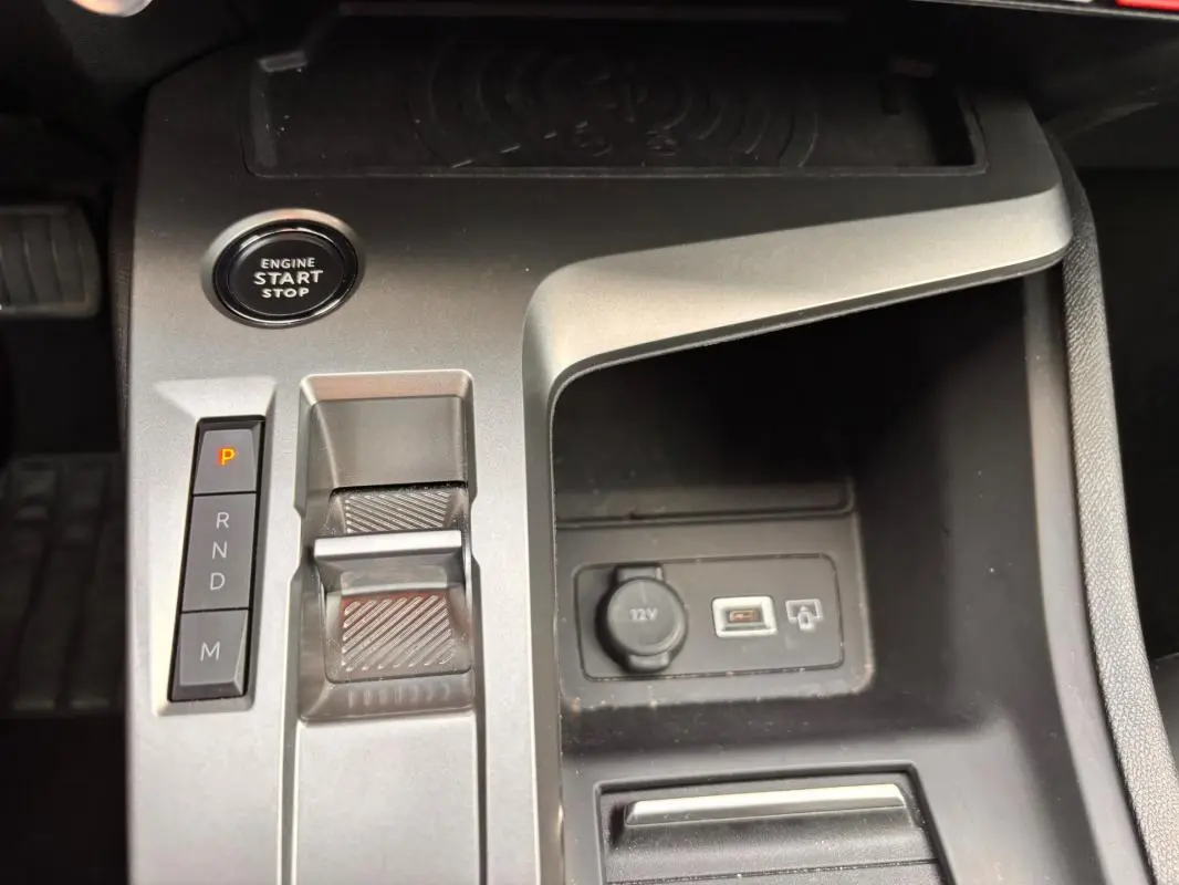 Vue rapprochée de la console centrale grise de la Peugeot 308 Hybrid 145 e-DCS6 Allure avec bouton start/stop et levier de vitesses automatique.