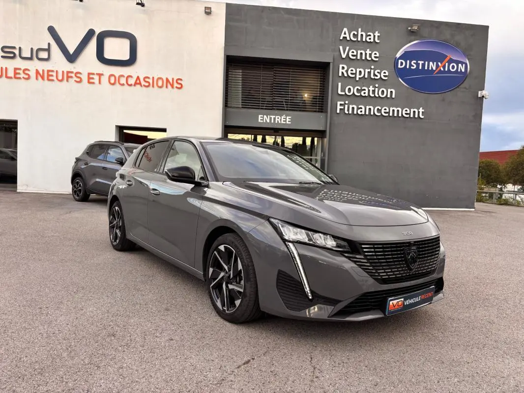 Peugeot 308 Hybrid gris vue 3/4 avant droit, jantes alliage 17 pouces et calandre noire distinctive.