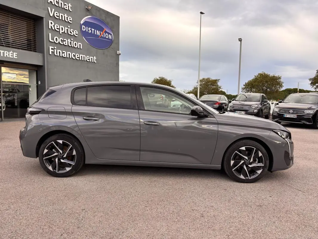 Peugeot 308 gris vue de profil côté gauche, jantes alliage 17 pouces et vitres teintées visibles.
