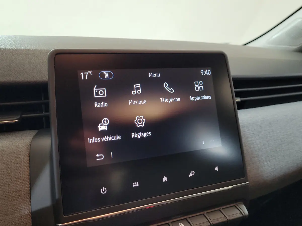 Écran tactile central allumé de la Renault Clio bleu, affichant le menu principal avec options multimédia et réglages.