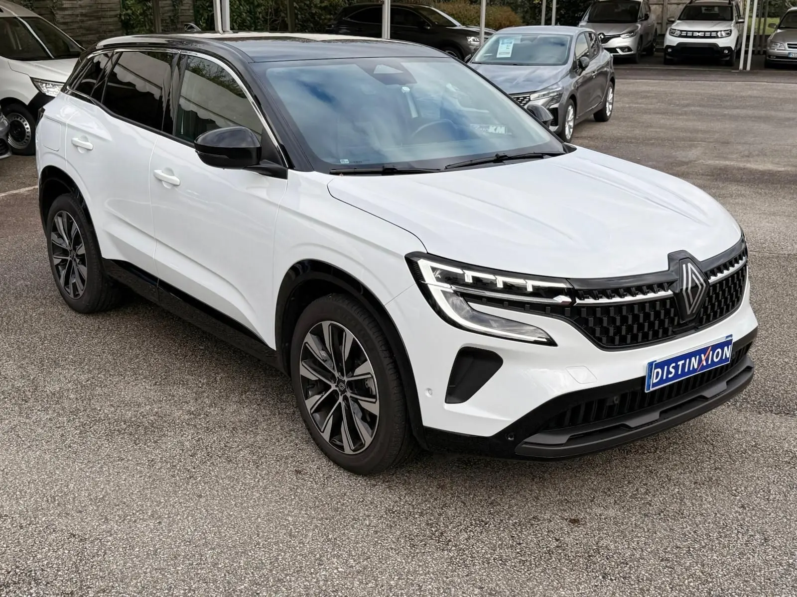 Renault Austral E-Tech 200 blanc nacré avec toit noir, vue 3/4 avant droit, calandre noire et jantes bi-ton.