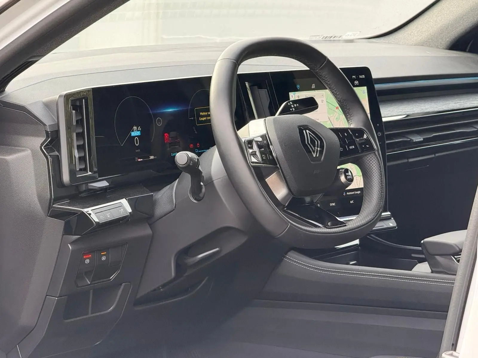 Vue intérieure côté conducteur du Renault Austral E-Tech 200 hybride, avec tableau de bord numérique et écran tactile central.