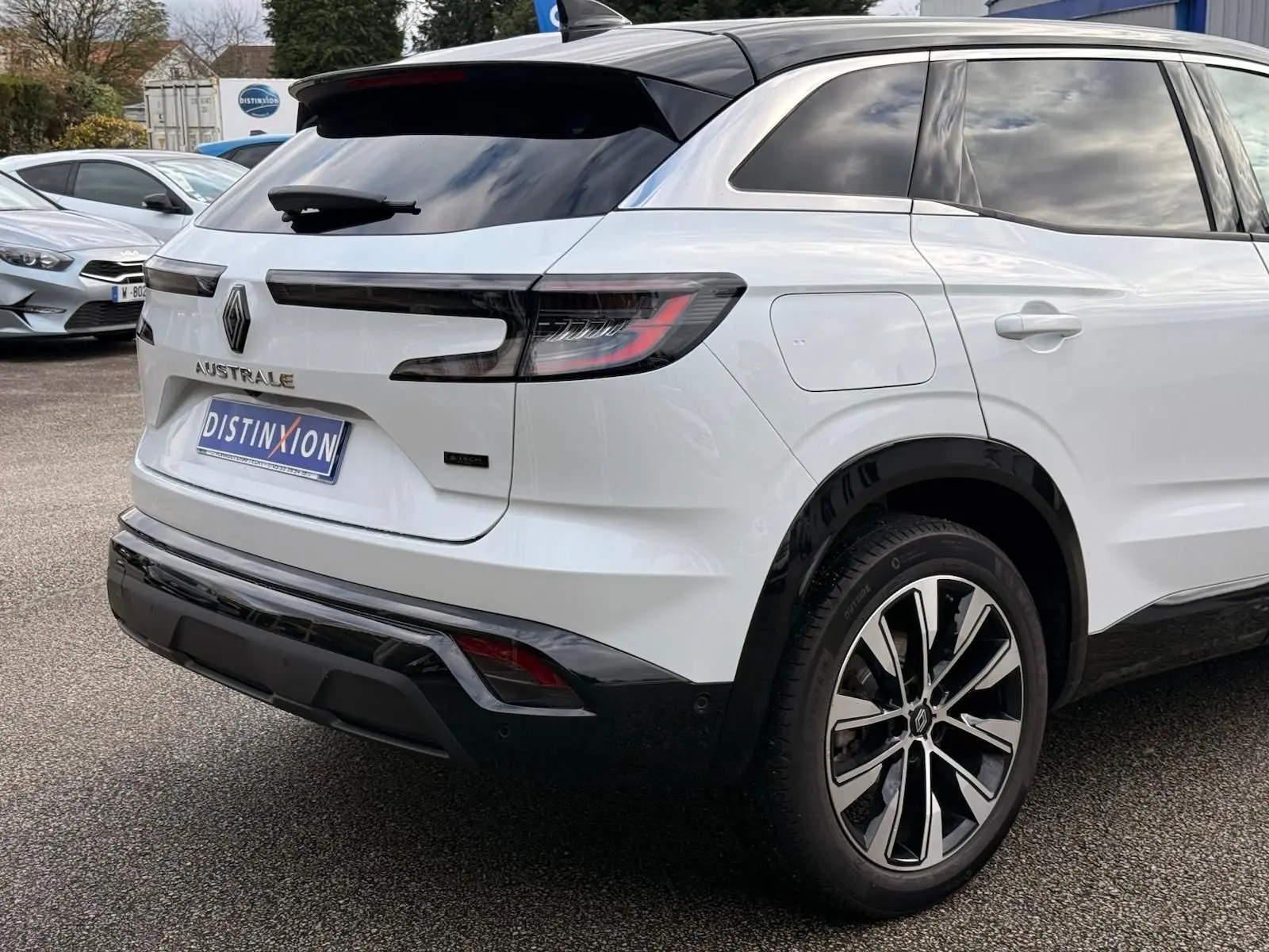Vue 3/4 arrière droite du Renault Austral E-Tech 200 blanc nacré avec toit noir et jantes biton modernes.