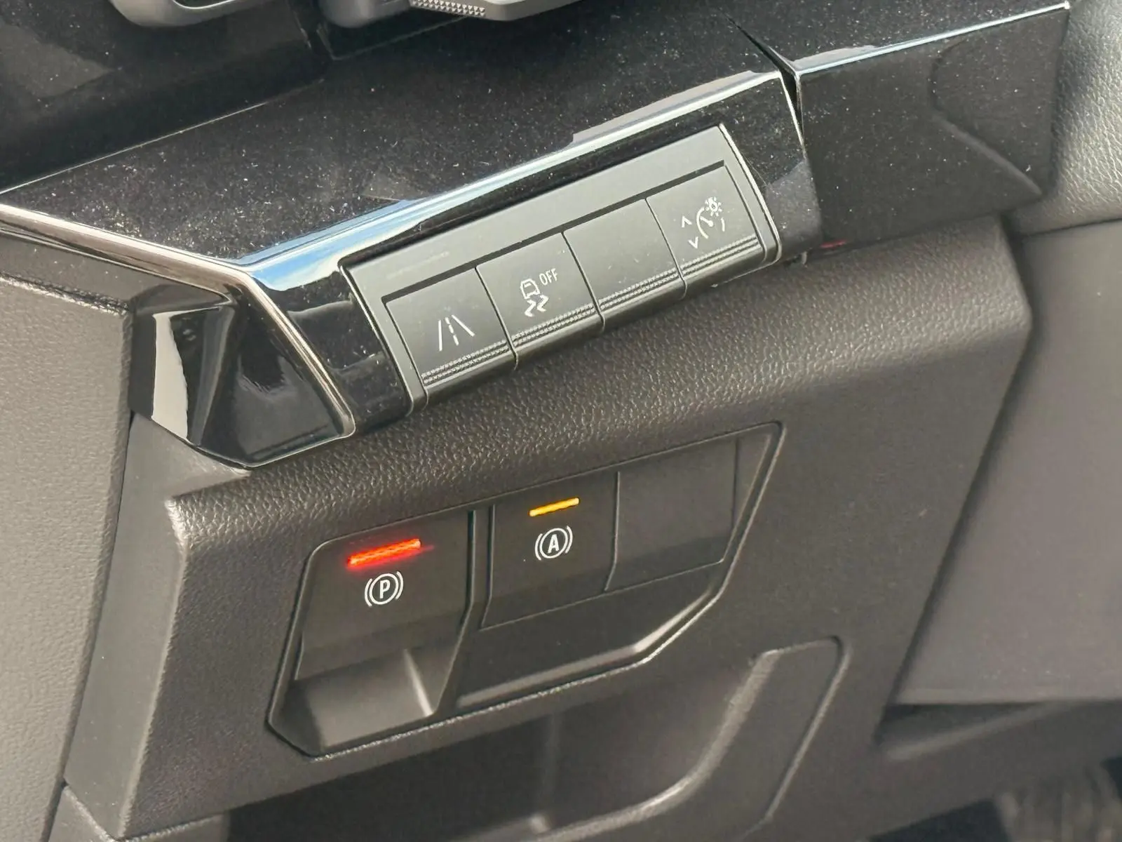 Gros plan sur les commandes de sécurité et assistance du tableau de bord du Renault Austral E-Tech 200 blanc nacré.