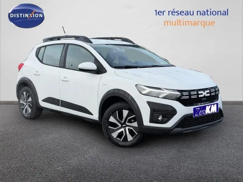 Vue 3/4 avant droite d'une Dacia Sandero 2025 blanche Glacier avec jantes noires et détails noirs contrastants.